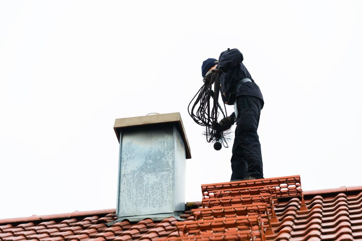 Close-up of a hand tuckpointing a mortar joint on a brick chimney