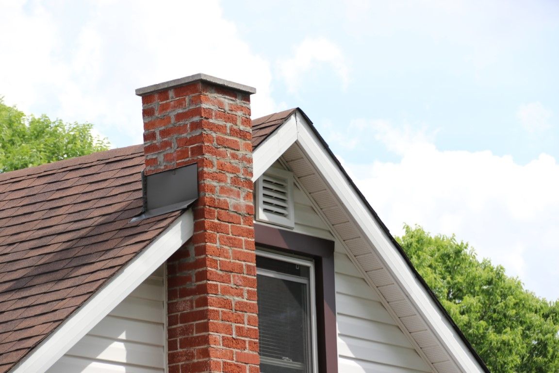 Chimney technician on a residential rooftop