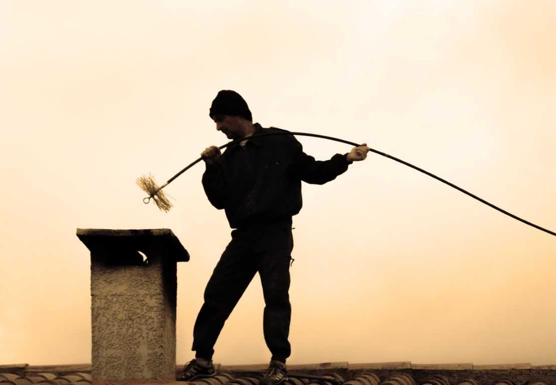 Chimney sweep cleaning a residential flue